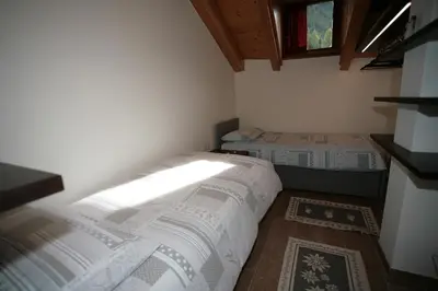 a small room with two beds and a window at Residence Anny in Canazei