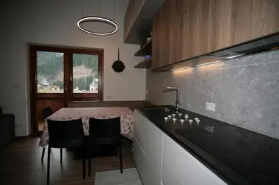 a kitchen with a table with chairs and a counter top at Residence Anny in Canazei
