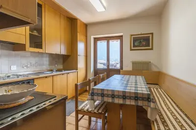 a kitchen with a table and a sink and a stove at Casa Elena in Canale dʼAgordo
