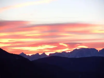 a sunset over a mountain range with mountains at Appartamento Casa Fia per gruppi e famiglie in Tesero
