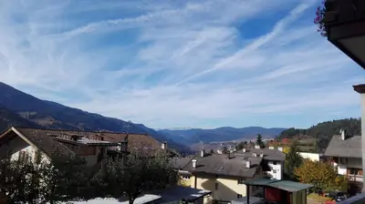a view of a town with mountains in the background at Appartamento Casa Fia per gruppi e famiglie in Tesero