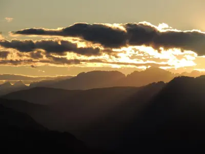 a sunset in the mountains with clouds in the sky at Appartamento Casa Fia per gruppi e famiglie in Tesero