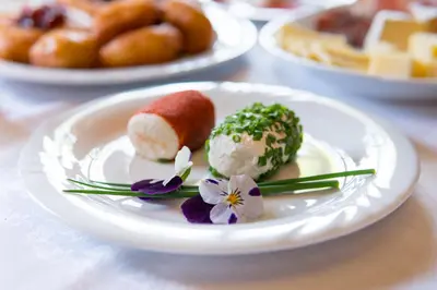 a white plate with some food on a table at Gönnerhof in Perca