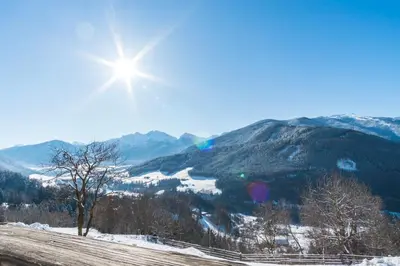 a sun shining over a snow covered mountain range at Gönnerhof in Perca