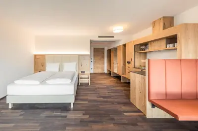 a bedroom with two beds and wooden cabinets at Weingut Moser Apartments in Caldaro