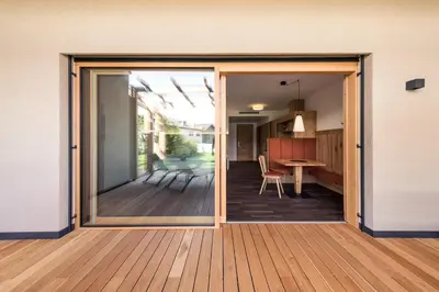 a sliding glass door leading to a kitchen and a dining room at Weingut Moser Apartments in Caldaro