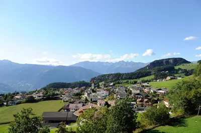 a small town in a green valley with mountains at Spitalerhof Apartment & Sauna in Verano