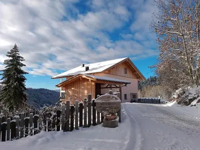 a building with a fence in the snow at Spitalerhof Apartment & Sauna in Verano