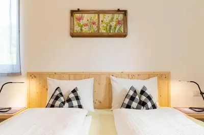 a bedroom with two beds and a picture on the wall at Spitalerhof Apartment & Sauna in Verano
