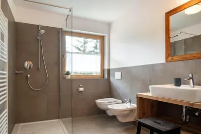 a bathroom with a shower and a toilet and a sink at Spitalerhof Apartment & Sauna in Verano