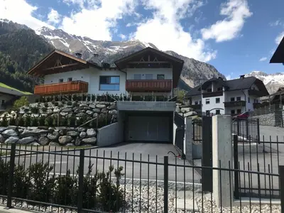 a house with a garage in front of a mountain at Oberkircher in Fundres