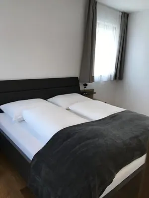 a bedroom with a bed with white sheets and a window at Oberkircher in Fundres