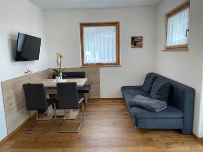 a living room with a table and a blue couch at Oberkircher in Fundres