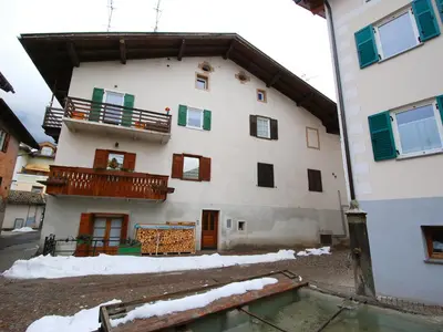 a white building with flowers in front of it at Apartment Garibaldi by Interhome in Predazzo