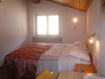 a bedroom with a bed and a cabinet and a sink at Garnì Villa Cecilia in Mazzin