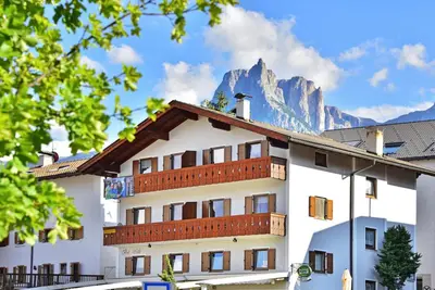 a white building with a mountain in the background at Apartment Gertrud in Castelrotto