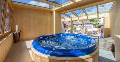 a large tub in a room with a large window at Garni Residence Trocker in Castelrotto