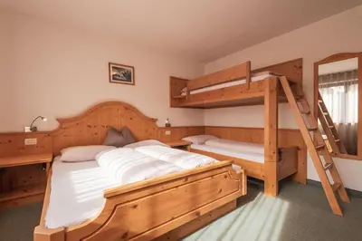 a bedroom with two bunk beds and a ladder at Garni Residence Trocker in Castelrotto