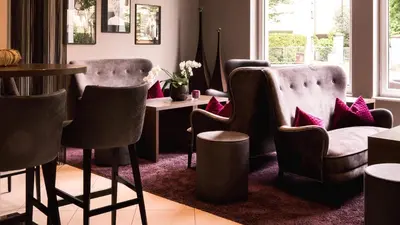 a living room with two chairs and a table at City Hotel Merano in Merano