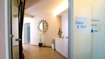 a hallway with a bathroom with a mirror and a sink at City Hotel Merano in Merano