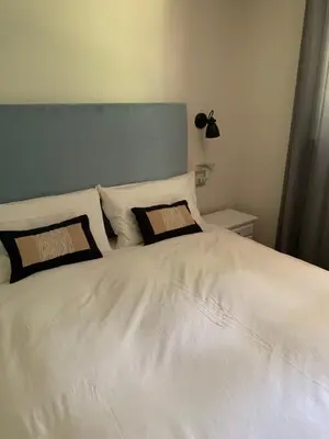 a white bed with two pillows on top of it at Cavalese luxury mountain and sky in Cavalese