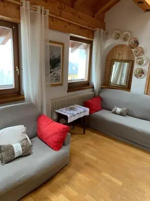 a living room with two couches and red pillows at Cavalese luxury mountain and sky in Cavalese