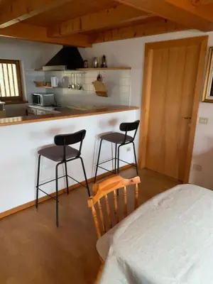 a kitchen with two bar stools and a counter at Cavalese luxury mountain and sky in Cavalese
