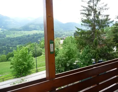 a window with a view of a field and trees at Cavalese luxury mountain and sky in Cavalese