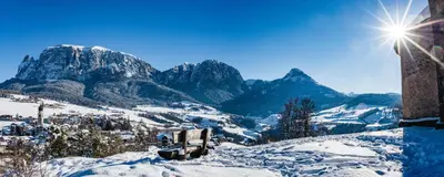 a snow covered mountain with the sun in the sky at Merlhof in Fiè