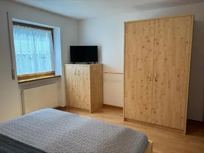 a bedroom with wooden cabinets and a bed and a television at Obereggen - Anna in Eggen