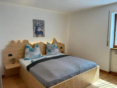 a bedroom with a wooden bed with blue pillows at Obereggen - Anna in Eggen