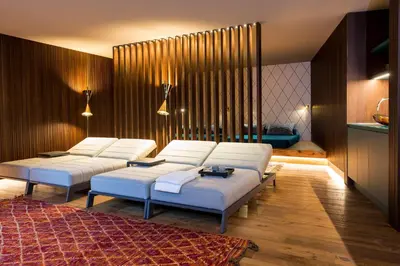 a living room with three white beds and a rug at ANTON Dolomites Hideaway in Brunico