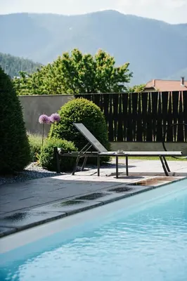 a bench sitting next to a swimming pool at ANTON Dolomites Hideaway in Brunico