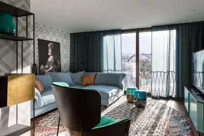 a living room with a blue couch and a window at ANTON Dolomites Hideaway in Brunico