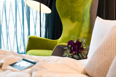 a bed with a remote control and flowers on it at ANTON Dolomites Hideaway in Brunico
