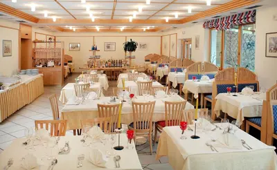 a dining room with white tables and chairs at Hotel Rierhof in Chiusa