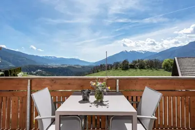 a table and chairs on a balcony with mountains at Panorama Residence Schlossblick in Rodengo
