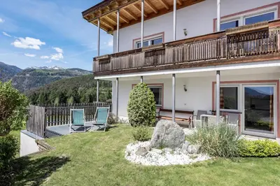 a house with a balcony and two chairs on a yard at Panorama Residence Schlossblick in Rodengo