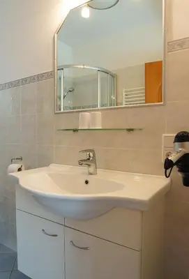 a bathroom with a white sink and a mirror at Weingut & Apartments Weitgruber Raffeis in Merano