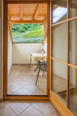 a glass door leading to a patio with a table at Weingut & Apartments Weitgruber Raffeis in Merano
