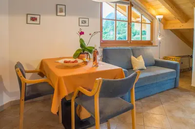 a dining room with a table and a couch at Weingut & Apartments Weitgruber Raffeis in Merano