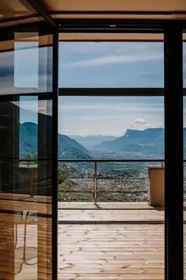 a view of the mountains through a glass door at farnhaus in Tirolo