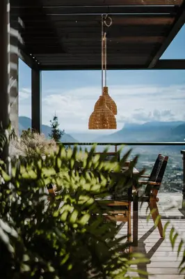 a pendant light hanging from a porch with a view of the ocean at farnhaus in Tirolo