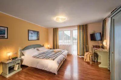 a hotel room with a bed and a table and a desk at Hotel Bad Salomonsbrunn in Anterselva di Mezzo