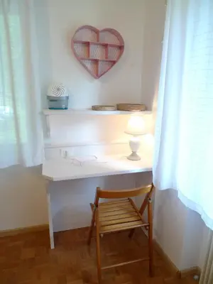 a desk with a heart on the wall and a chair at Casa Sorarù in Rocca Pietore