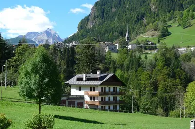 a house on a hill in a green field at Casa Sorarù in Rocca Pietore