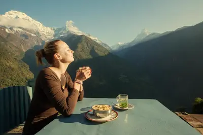 a woman sitting at a table with a bowl of food at Casa Sorarù in Rocca Pietore