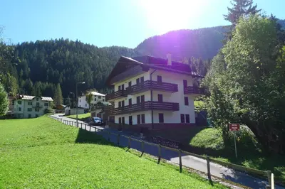 a house on a hill with a fence around it at Casa Sorarù in Rocca Pietore