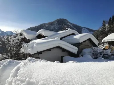 a snow covered house with a pile of snow at Casa Sorarù in Rocca Pietore