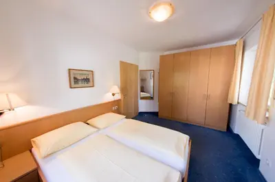 a bedroom with a large white bed in it at Apartments Villa Majense in Merano